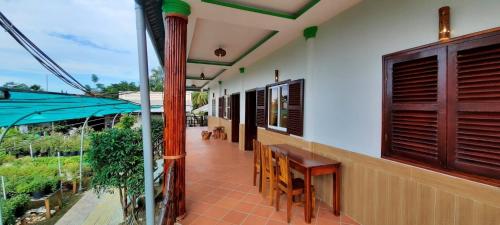 a balcony of a house with a table and chairs at Flower & Frog Homestay in Sa Ðéc