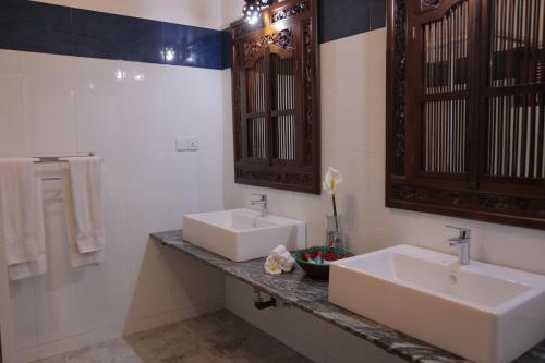 ein Badezimmer mit 2 Waschbecken, einem Spiegel und Handtüchern in der Unterkunft Wunderbar Beach Hotel in Bentota