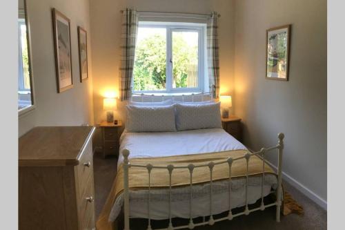 ein kleines Schlafzimmer mit einem Bett und einem Fenster in der Unterkunft Bar Lodge at Broxa in Long Riston
