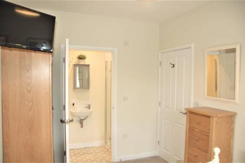 a bathroom with a sink and a toilet and a mirror at Bar Lodge at Broxa in Long Riston