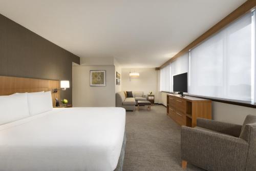 a hotel room with a bed and a flat screen tv at Hyatt Place Chicago O'Hare Airport in Rosemont