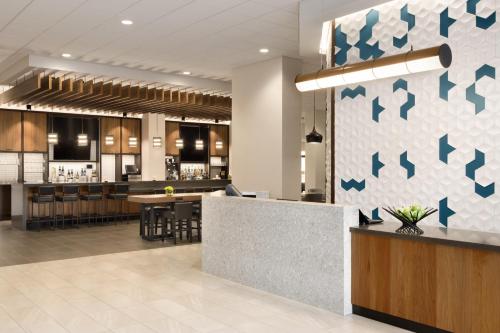 
a kitchen with a white counter top and a black counter top at Hyatt Place Chicago O'Hare Airport in Rosemont
