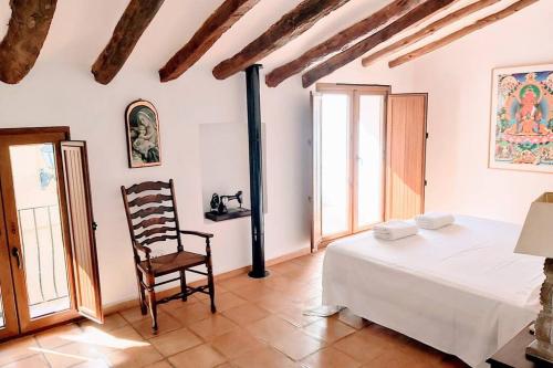 1 dormitorio con 1 cama y 1 silla en una habitación en CASA NICOLE Naturaleza, Montañas y Piscina Privada en Alicante, en Carroja