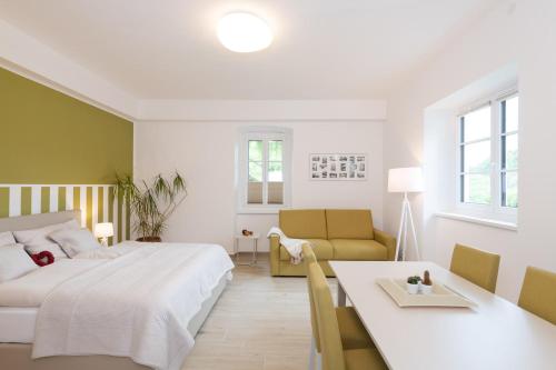 sypialnia z łóżkiem, stołem i kanapą w obiekcie Villa Bella Vista - Apartment Green w mieście Pörtschach am Wörthersee