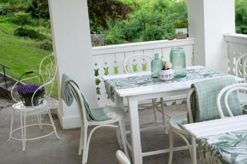 un tavolo bianco e sedie su un portico di Villa Bella Vista - Apartment Green a Pörtschach am Wörthersee