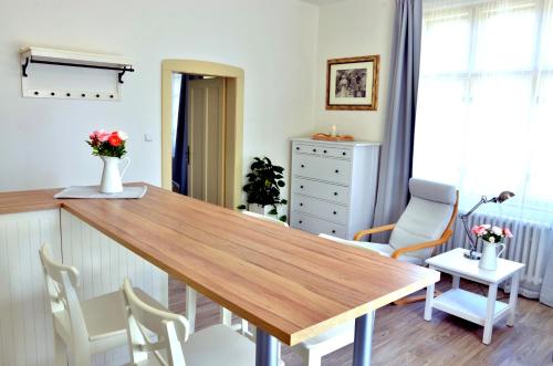 a dining room with a wooden table and chairs at Apartmány Vila Mánička in Kácov