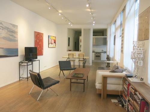 a living room with a couch and a table at Loft Marais Gallery CityCosy in Paris