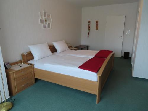 ein Schlafzimmer mit einem großen Bett mit einer roten Decke in der Unterkunft Gästehaus Spieker in Horn-Bad Meinberg