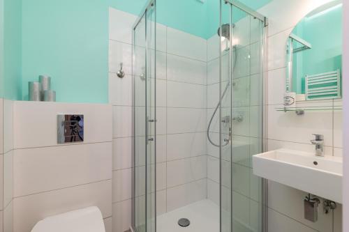 ein Bad mit einer Glasdusche und einem Waschbecken in der Unterkunft Apartament Świętokrzyska by Your Freedom in Warschau