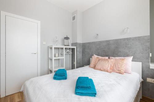 ein Schlafzimmer mit einem weißen Bett und blauen Handtüchern darauf in der Unterkunft Apartament Świętokrzyska by Your Freedom in Warschau