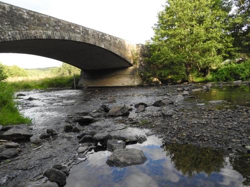 a bridge over a river with rocks in the water at Valgrange in Tenneville
