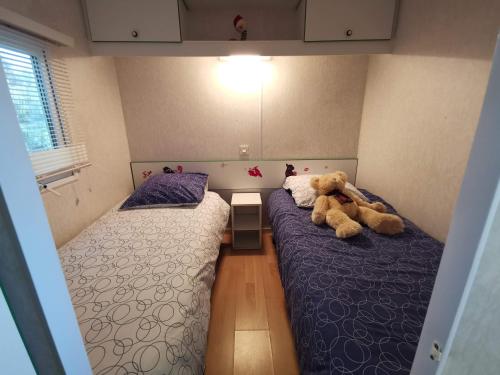 - une chambre avec 2 lits avec un ours en peluche dans l'établissement Mobile Home at La Petite Lande, à Pierrefiche