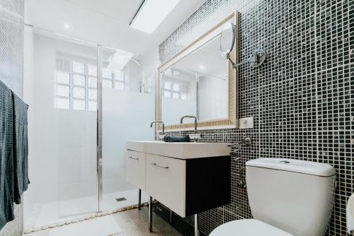 a bathroom with a toilet and a sink and a mirror at Casa La Fula Negra in Los Realejos
