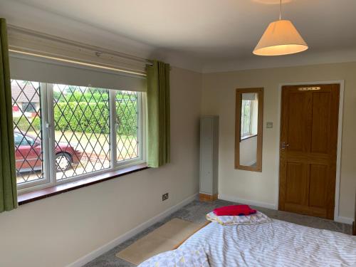 a bedroom with a bed and a window at Eastfield B & B in Ringwood