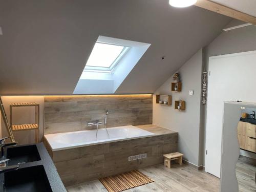 uma casa de banho com uma grande banheira e uma clarabóia em Valgrange em Tenneville