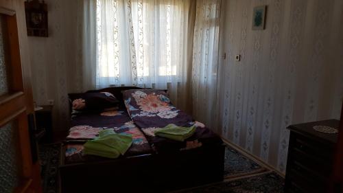 a bed sitting in a room with a window at Сара in Gabrovo