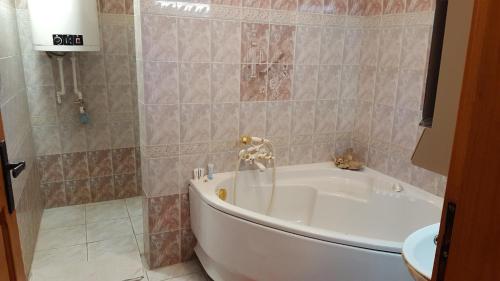 a bath tub in a bathroom with a sink at Сара in Gabrovo