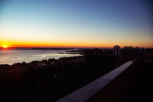 a sunset over the ocean with the sun setting at Blue Tree Towers Millenium Porto Alegre in Porto Alegre