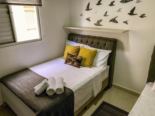 - une chambre avec un lit doté d'oreillers jaunes et d'une fenêtre dans l'établissement APARTMENTFORSTAY 18 Tânger, à Marília