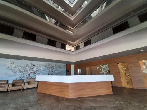 a large lobby with a large table and chairs at VITS The Somnath Gateway in Somnath
