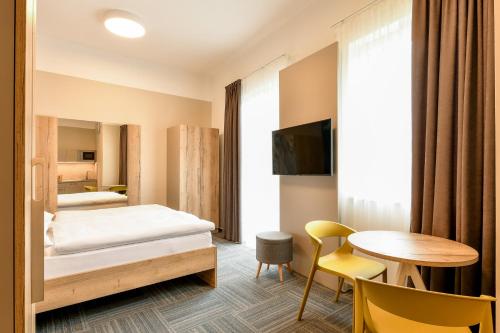 um quarto de hotel com uma cama e uma mesa em SLADOVNA Apartments em Olomouc