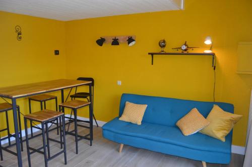 uma sala de estar com um sofá azul e uma mesa em Maison à Westende em Middelkerke