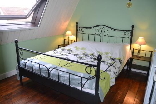 a bed in a room with two lamps and a window at Maison à Westende in Middelkerke