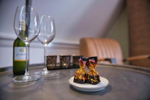 zwei Figuren von zwei Katzen auf einem Tisch mit Weingläsern in der Unterkunft Com-In in Alkmaar