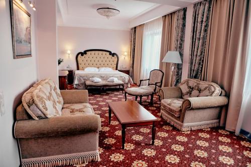 a living room with a bed and chairs and a table at Ring Premier Hotel in Yaroslavl