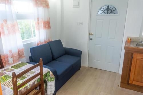 a living room with a blue couch and a window at Cleopatra Villas - Sea View in Rodney Bay Village