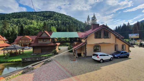 a house with a car parked in a parking lot at Smerekova Hata in Yablunytsya