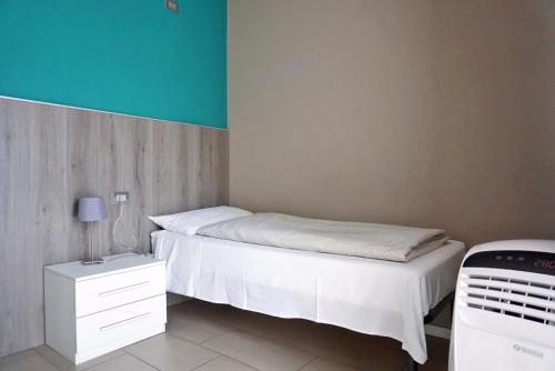 a bedroom with a white bed and a blue wall at I Dodici mesi rooms&apartments in Trento