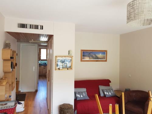 uma sala de estar com uma cama vermelha e um sofá em Appartement traversant résidence chaput 2 - 2 pièces - 6 personnes - vue sur front de neige em La Toussuire