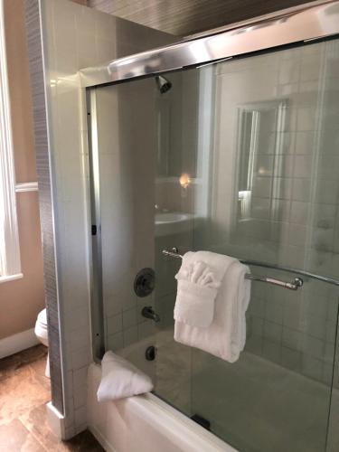 Un baño con ducha de cristal con toalla. en The Conch House Heritage Inn, en Key West