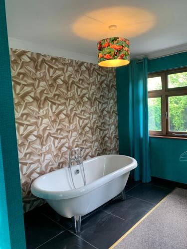 a bath tub in a bathroom with a wall at The Malthouse in Ironbridge