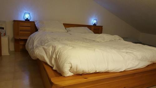 uma grande cama branca com duas luzes em cima em Tignes 1800 em Tignes