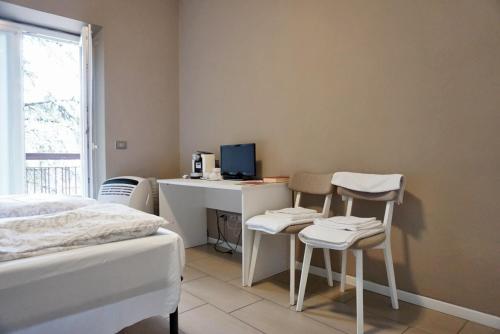 a bedroom with a desk with a computer and two chairs at I Dodici mesi rooms&apartments in Trento