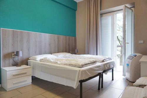 a bedroom with a bed and a blue wall at I Dodici mesi rooms&apartments in Trento