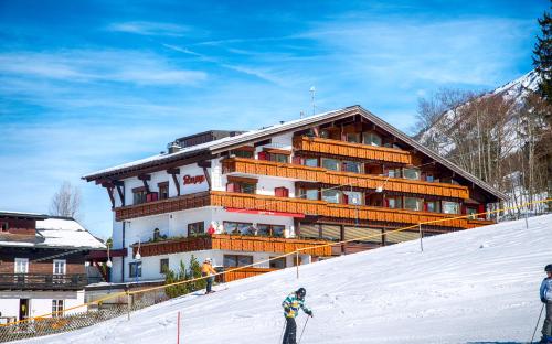 a building on top of a snow covered slope at Hotel Almhof Rupp in Riezlern