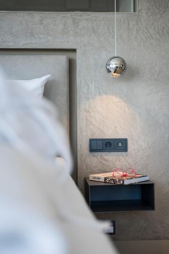 a bedroom with a bed and a night stand with a light at Appartementhotel Röhrenbach in Immenstaad am Bodensee