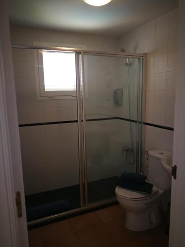 a bathroom with a shower and a toilet and a window at VV VALDECONCHA, piscina climatizada con SPA privado y vistas al mar in Caleta De Fuste
