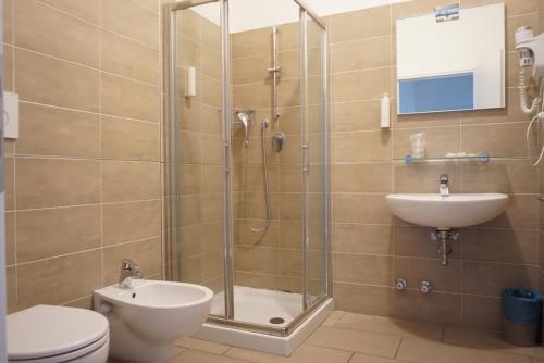 y baño con ducha, aseo y lavamanos. en I Dodici mesi rooms&apartments, en Trento