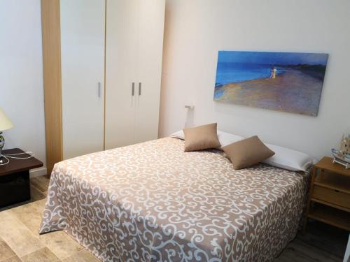 a bedroom with a bed with a painting on the wall at Casa Levante a 75 mt dalla spiaggia in Monopoli