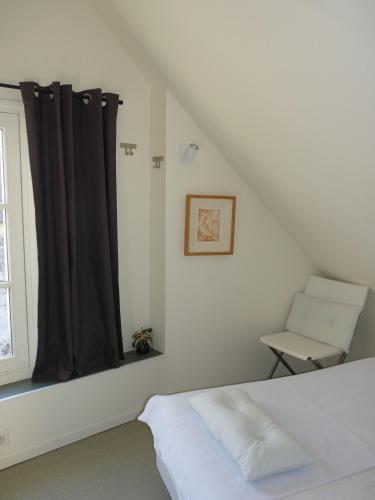 une chambre avec un lit, une fenêtre et une chaise dans l'établissement La Maison de Madame Baudy, à Giverny