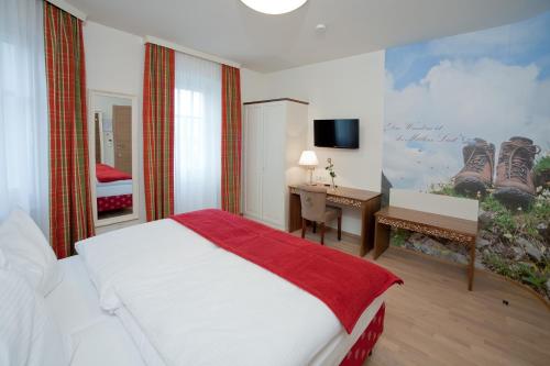 Schlafzimmer mit einem Bett, einem Schreibtisch und einem TV in der Unterkunft Gasthof Restaurant Zum Brauhaus in Hartberg