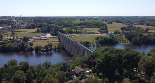 an aerial view of a bridge over a river at La Maison Ribotteau in LʼIsle-Jourdain