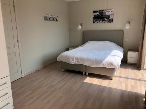 een slaapkamer met een bed en een houten vloer bij Palazzo by Villa Verde -Unique appartment- in De Haan