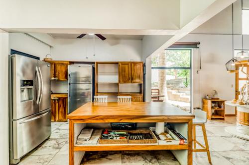 a kitchen with a wooden table and a refrigerator at Casa Guarumo Carrillo in Carrillo