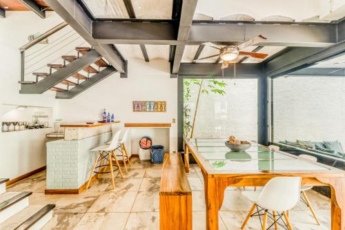 a dining room with a glass table and white chairs at Casa Guarumo Carrillo in Carrillo