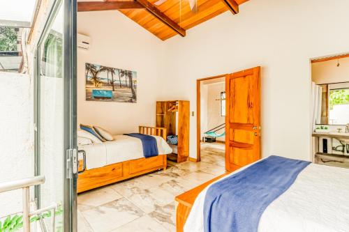 a bedroom with two beds and a sliding glass door at Casa Guarumo Carrillo in Carrillo